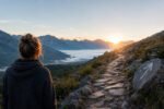 Person looking at a mountain trail at sunrise, symbolizing stages of spiritual awakening and inner searching.